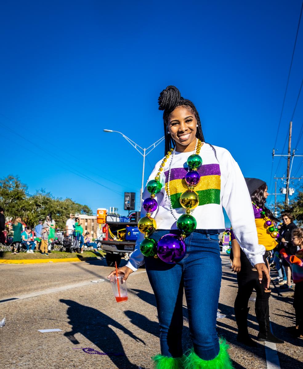 A young woman dresses in the purple, green and gold of Mardi Gras at the Krewe of Dionysus parade in Slidell.